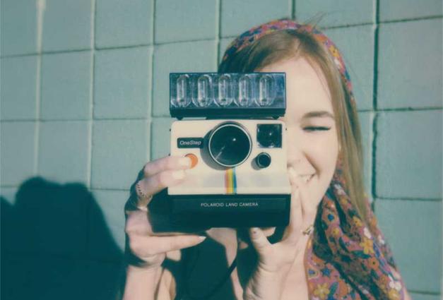 Woman holding a vintage Polaroid camera