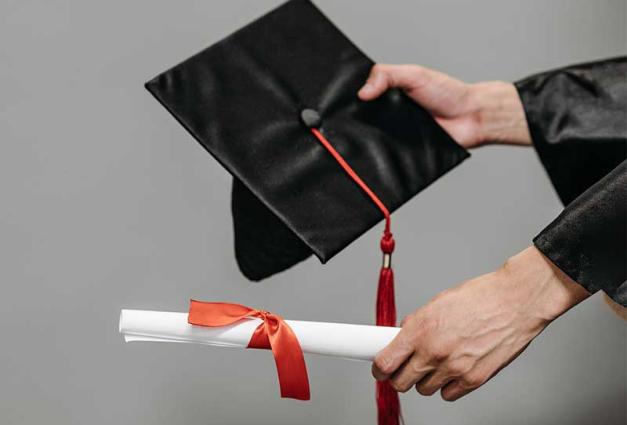 Person holding a graduation cap and diploma
