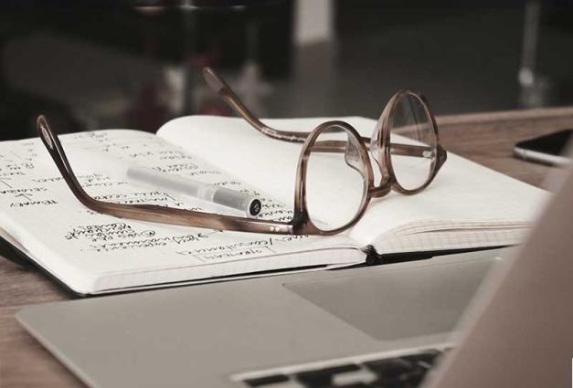 A photo showing glasses placed on top of a journal.