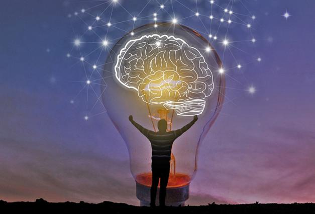 Man inside of a large lightbulb with an illustration of a brain illuminating it