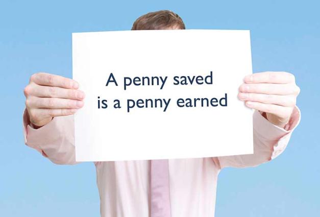 Man holding a sign with the proverb "a penny saved is a penny earned"