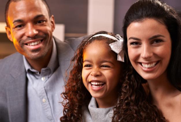 Image of interracial family sitting together smiling