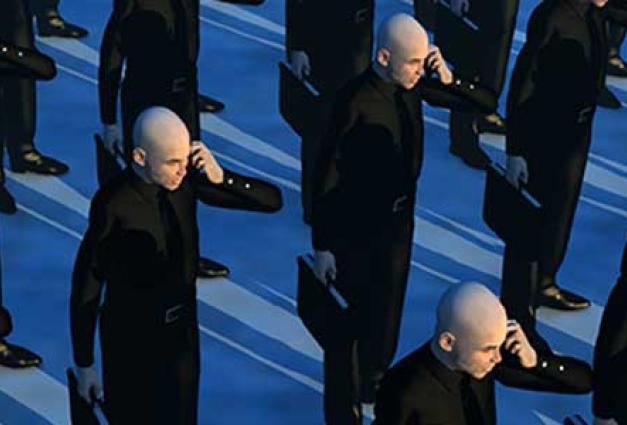 identical men in black suits with briefcases and cell phones against a blue background