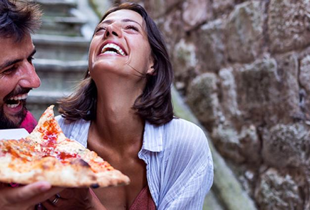 Smiling couple eating pizza