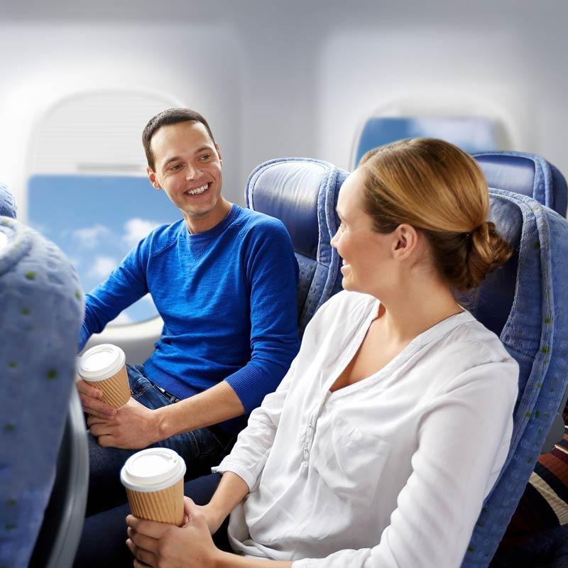 Young man and young woman sitting next to each other on an airplane