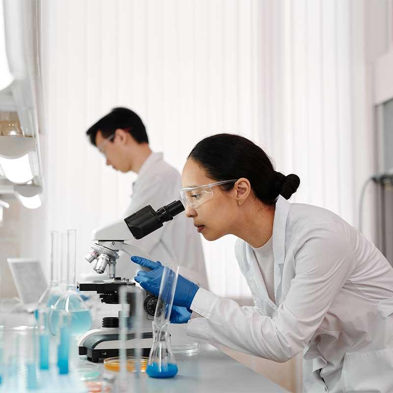 Woman in lab using a microscope