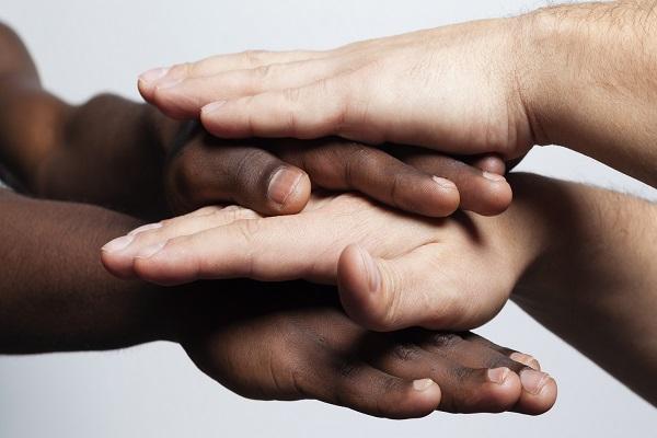 Image of alternating black and white hands on top of one another