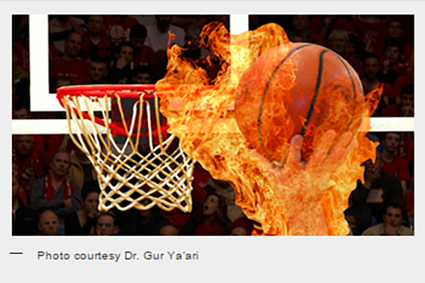 Image of a basketball on fire being pushed towards the basketball hoop