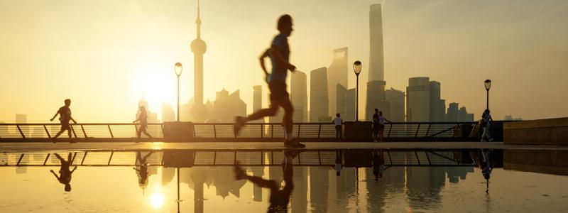 Image of person running in front of a city skyline