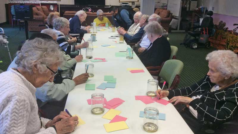 image of group of senior citizens writing down memories for their memory jars