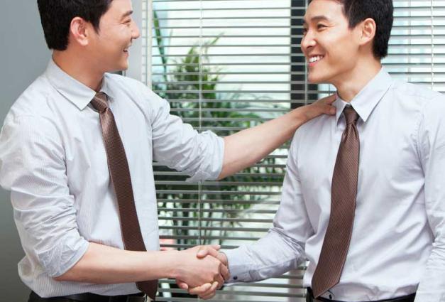 Young Businessman Congratulating Other Young Businessman