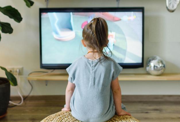 Young girl sitting in front of Television