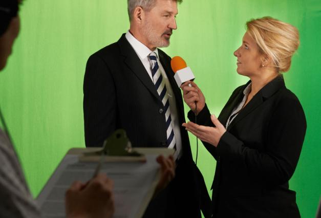 Female Presenter Interviewing In Television Studio With Crew