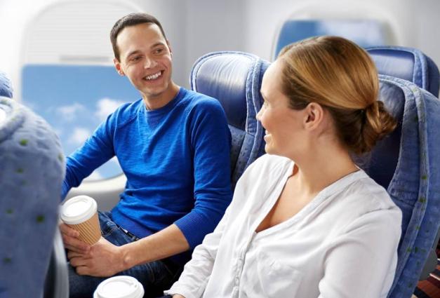 Young man and young woman sitting next to each other on an airplane