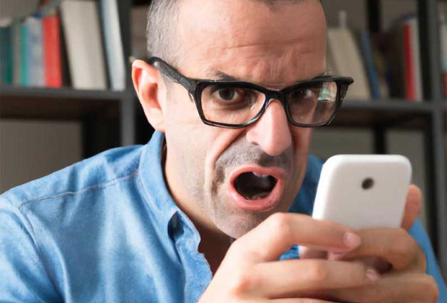 Angry man using mobile device