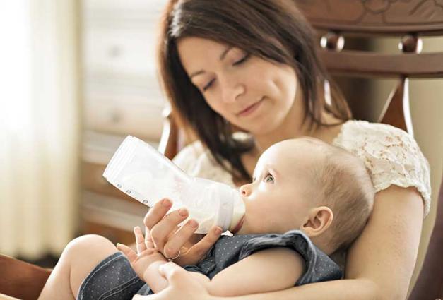 Woman bottle-feeding baby