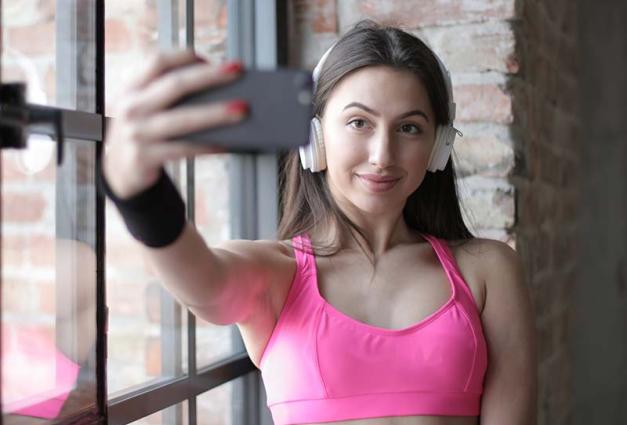 Young woman in sports bra taking a selfie