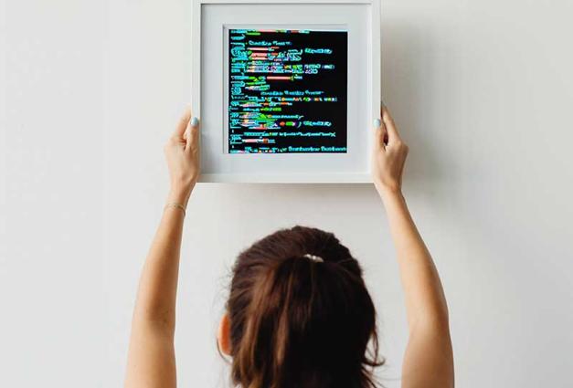 Woman hanging a picture of computer code