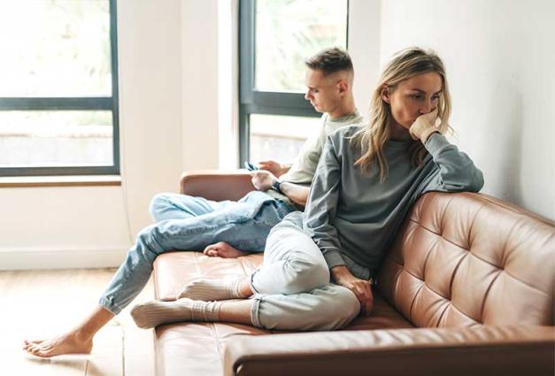Couple sitting on couch - woman looks distressed