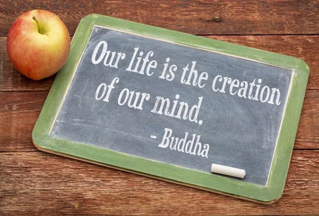 "Our life is the creation of our mind. -Buddha" written on a chalkboard