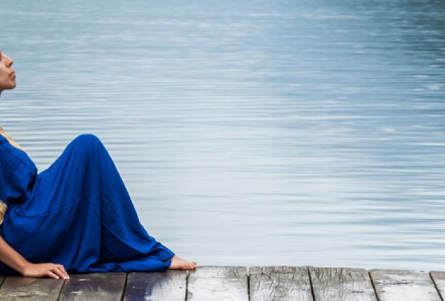 Woman sitting on a dock near a lake