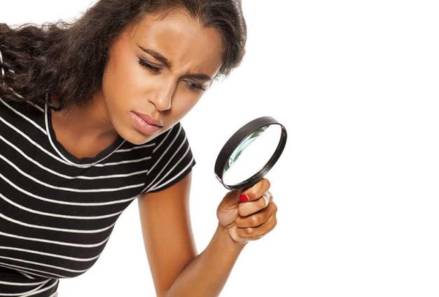 woman looking trough a magnifying glass