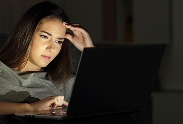 Worried woman using a laptop in the night
