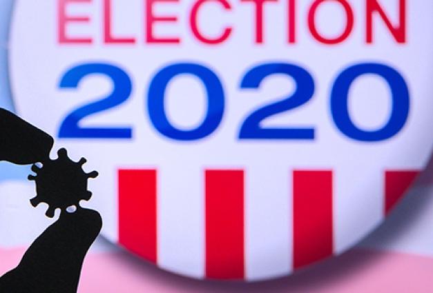 Hand silhouette hold covid 19 virus. Logo of USA presidental Election 2020 in background.