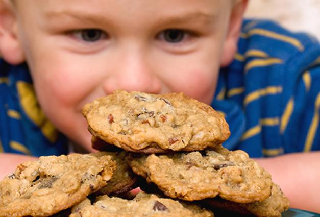 Young boy looking at plate of cookies