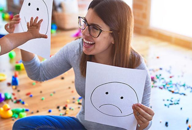 Teacher and toddler doing therapy using emoji emotions