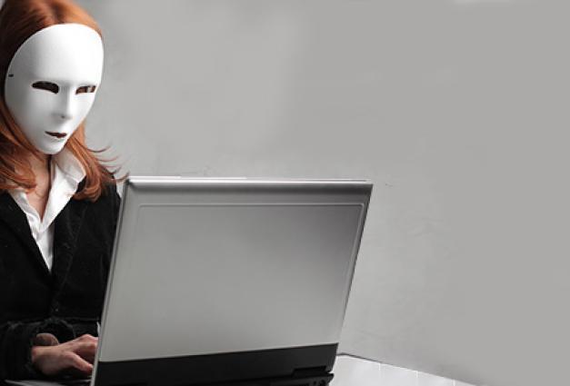 Woman wearing mask working on laptop computer
