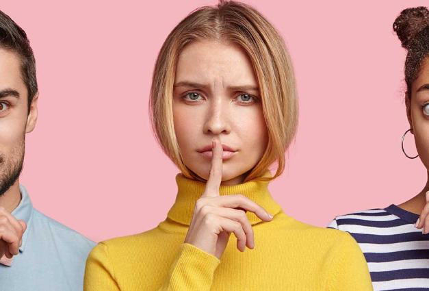 Set of serious young women and one bearded male show hush sign, demand to be quiet and not tell secret, keep fingers on lips. pose indoor against pink background. People say: Shh, stop talking