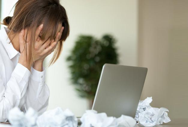 Stressed female worker feel despair surrounded by crumpled paper