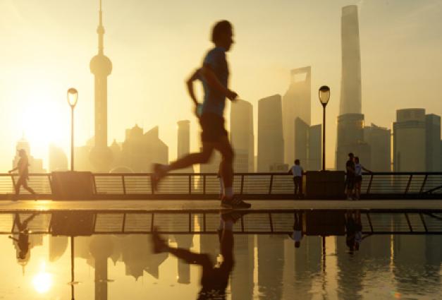 Image of person running in front of a city skyline