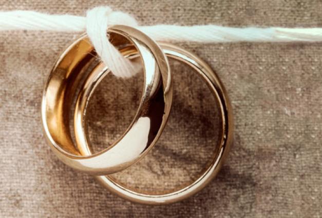 Image of two wedding bands tied together on a horizontal line of string