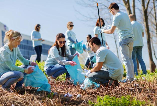 Image of young adults picking up trash and recycling