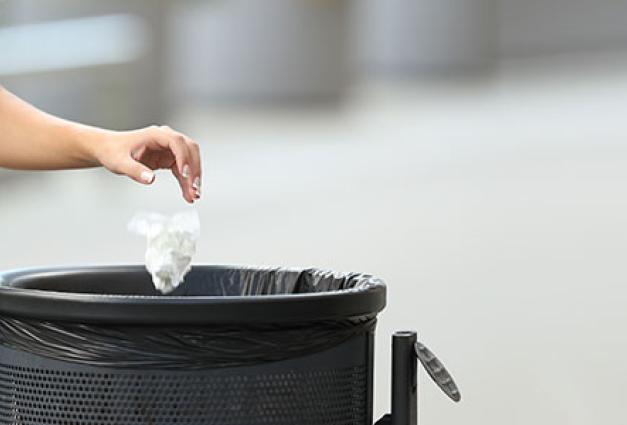 Image of woman throwing trash in can
