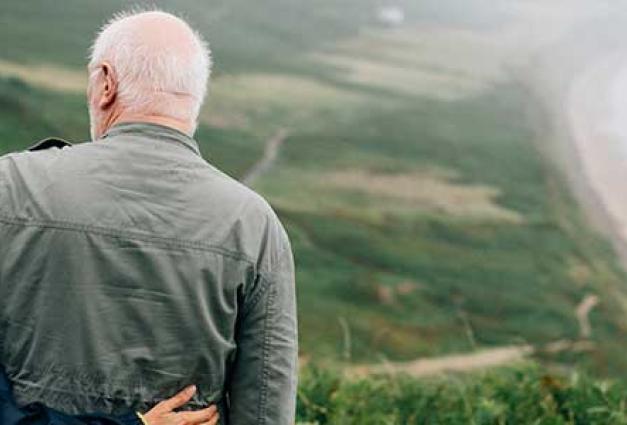 Older couple embracing on hill