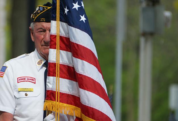 Elderly veteran holding flag