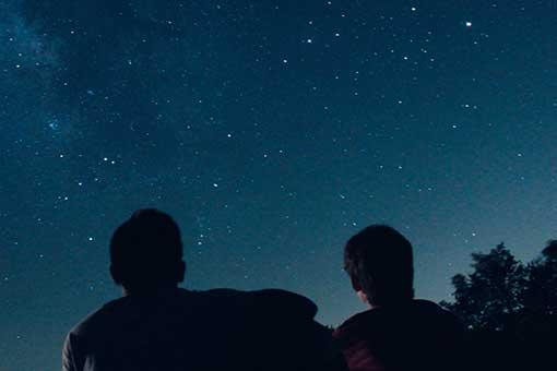 Silhouette photo of two men looking at evening starry sky