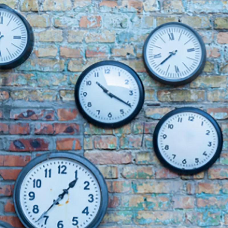 Clocks on a brick wall