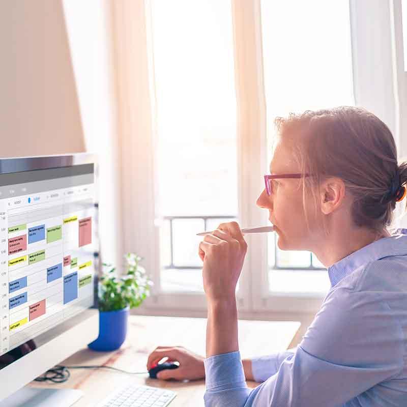 Woman at computer with calendar on screen
